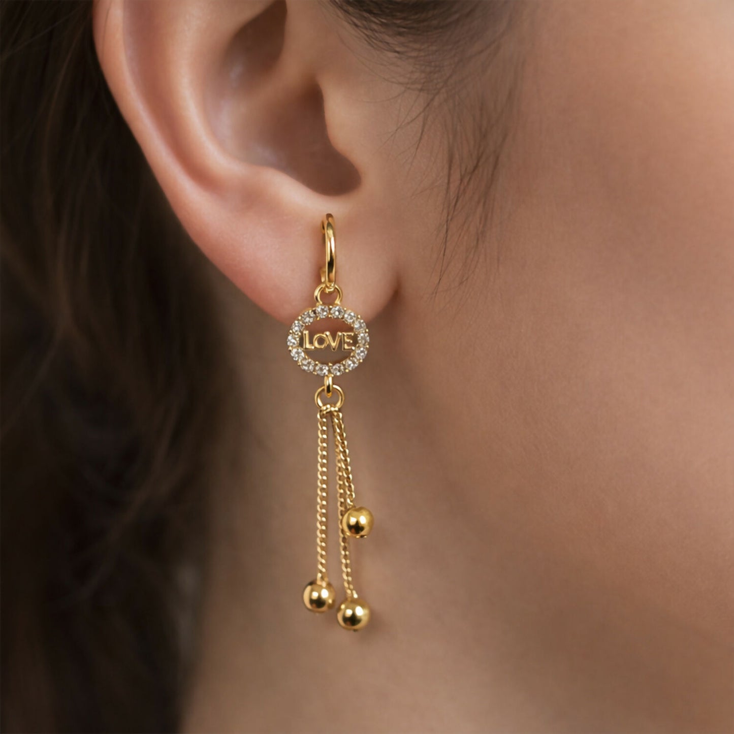 Love Charm Tassel Earrings with gold finish and sparkling crystals close up