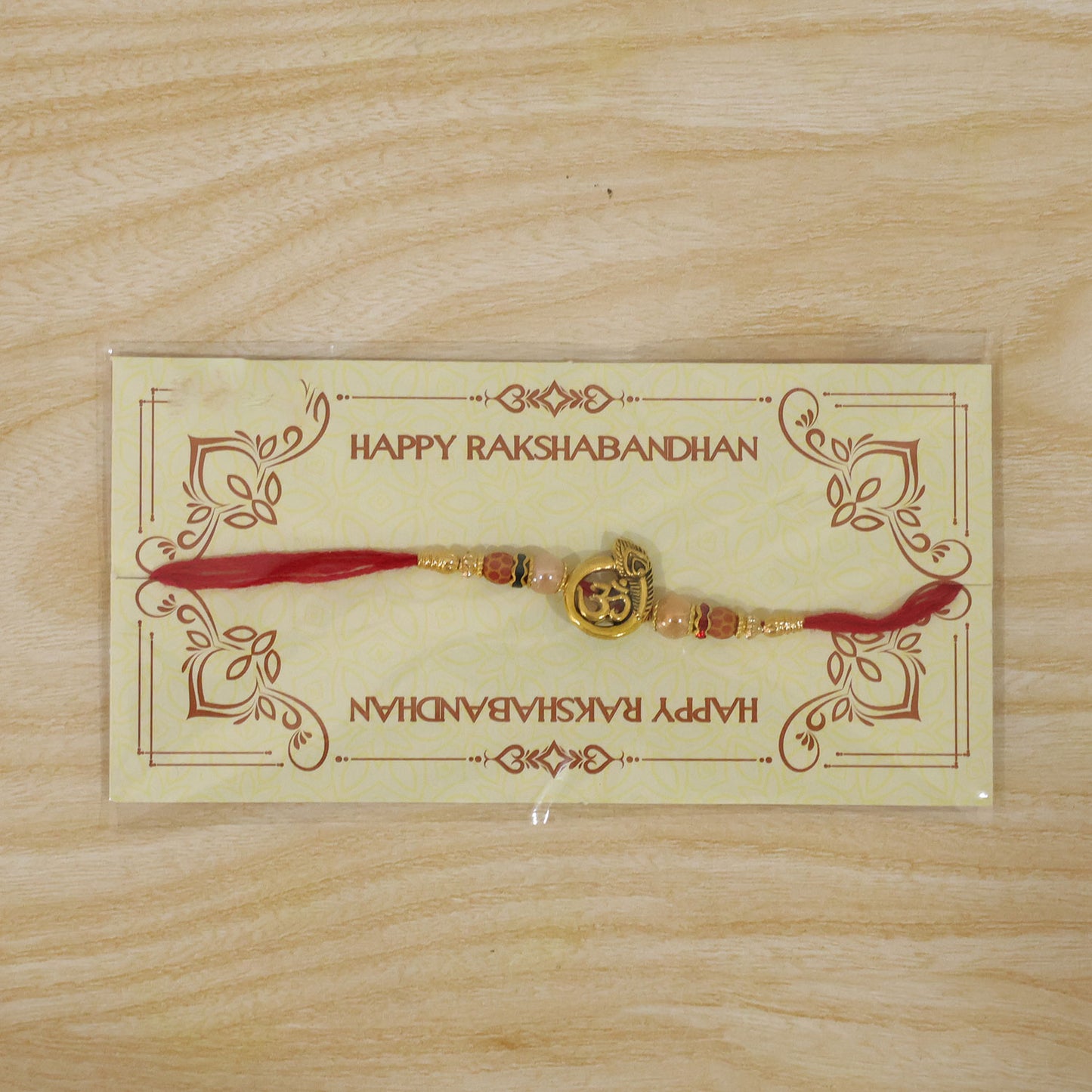 Om Peacock Golden Devotional Rakhi with Sacred Symbol, Pearl Beads and Red Thread