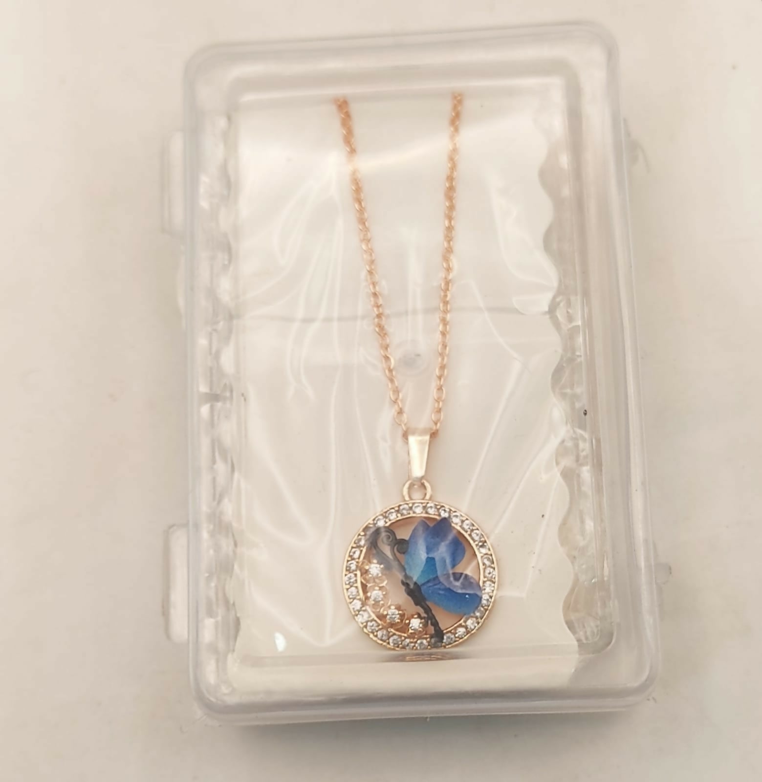 Elegant blue butterfly pendant hanging from rose gold plated necklace chain