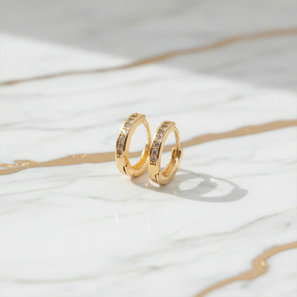 Gold finish crystal studded hoop earrings displayed to show classic circular design