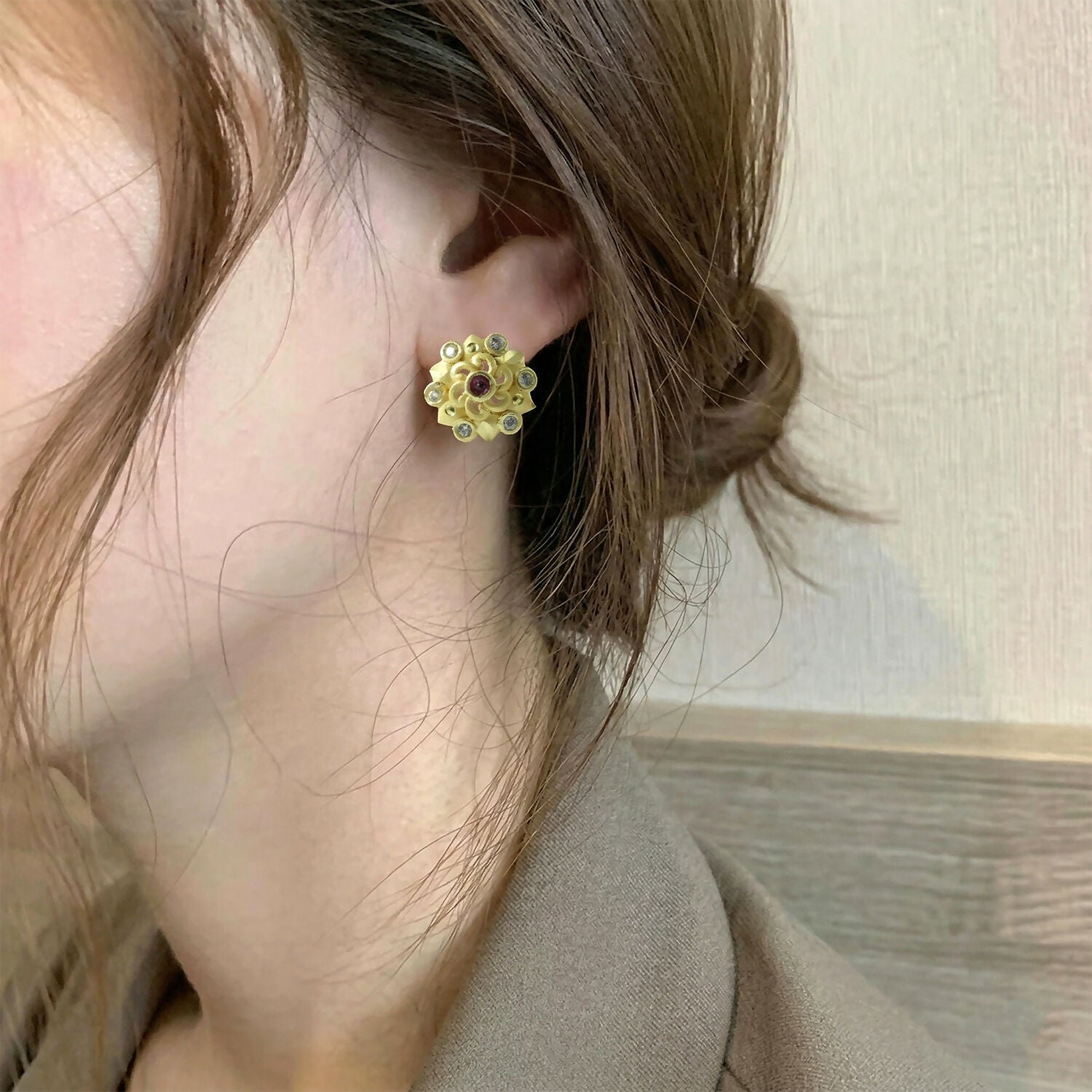 Gold stud earrings showcasing intricate floral pattern with multi-stones
