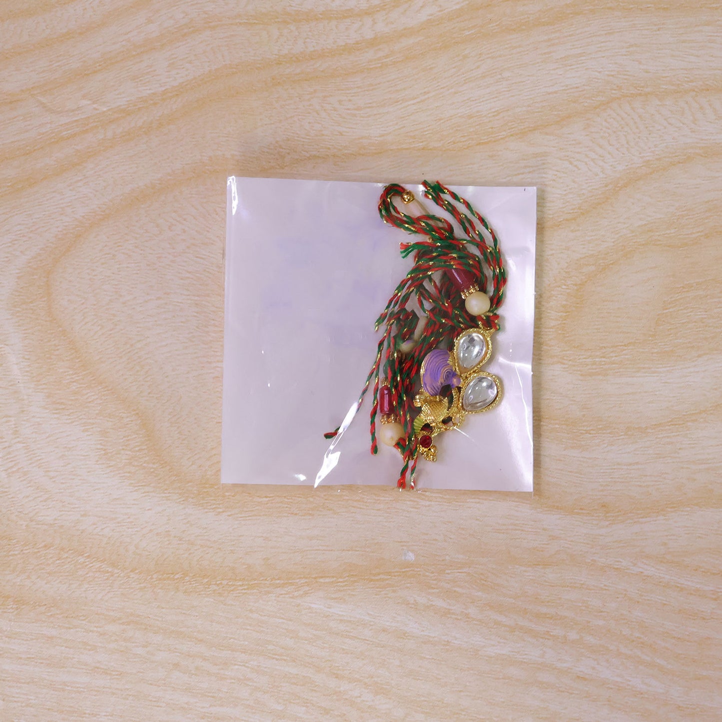 Floral Kundan Pendant Rakhi with Purple Peacock Accent