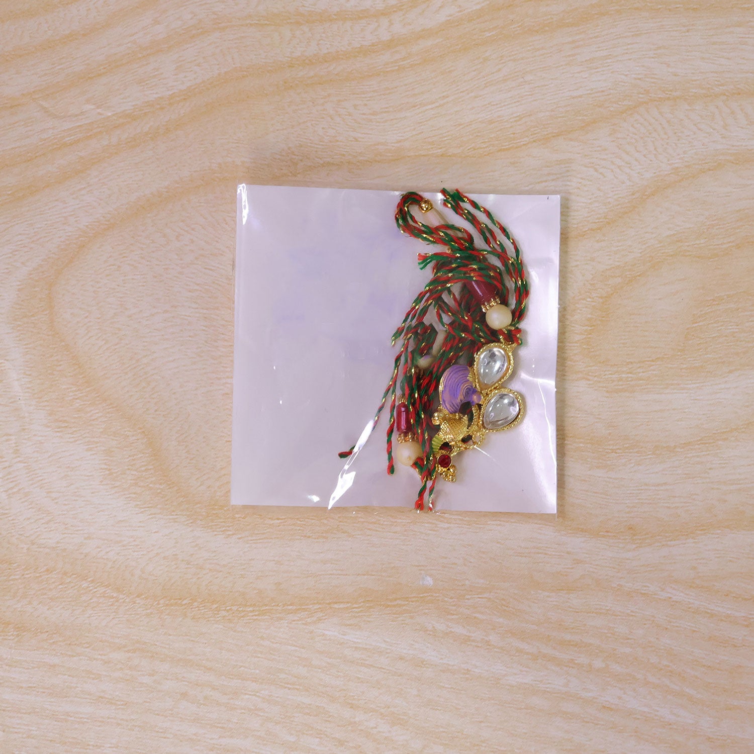 Floral Kundan Pendant Rakhi with Purple Peacock Accent