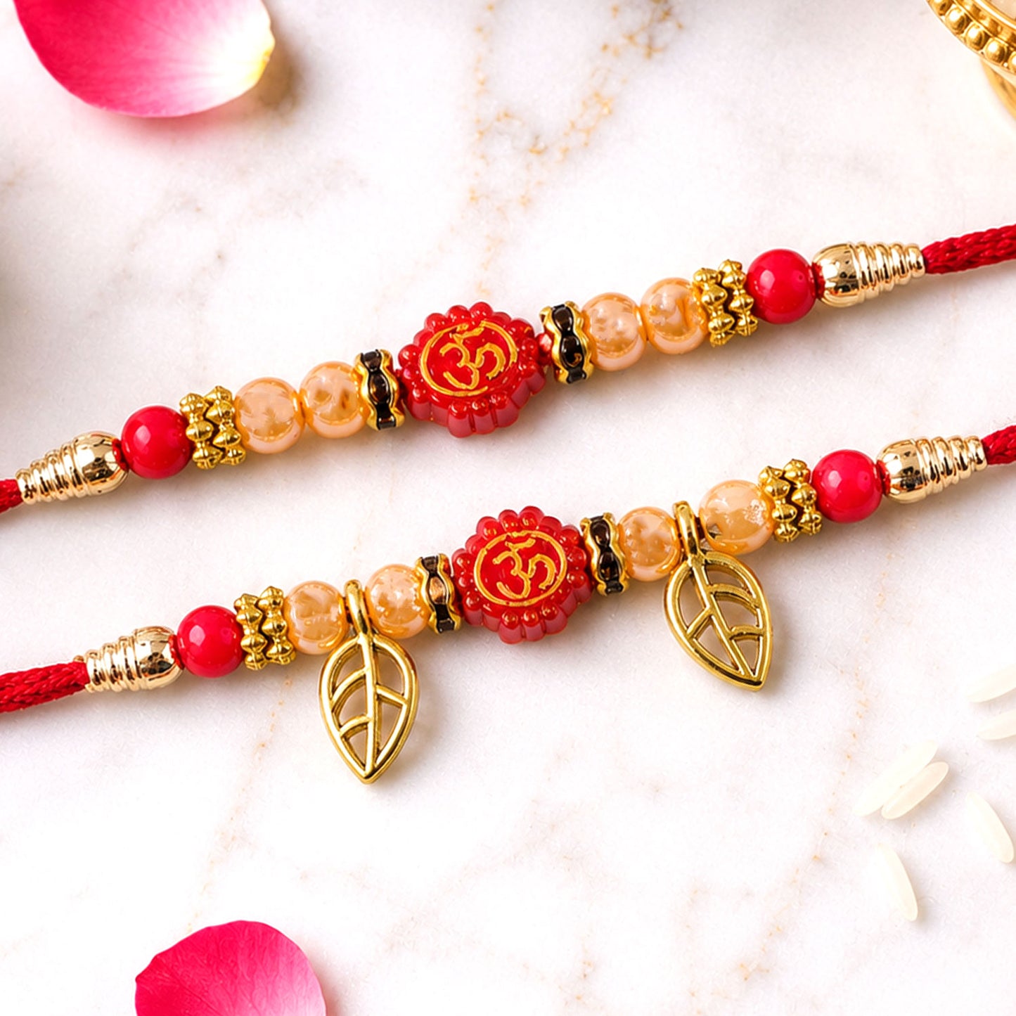 Couple Om Rakhi Set with Red Beads, Golden Leaf Charms and Festive Lumba Pair Design