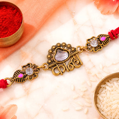 Antique Gold-Toned Kanha Rakhi with Kundan-Style Stone, Crystal Accents & Red Thread