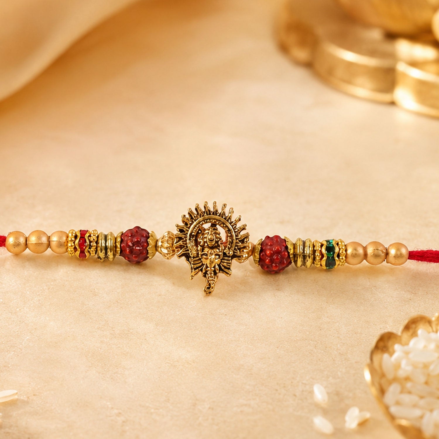 Ganesh Ji Antique Golden Devotional Rakhi with Red Beads and Pearl-Style Accents