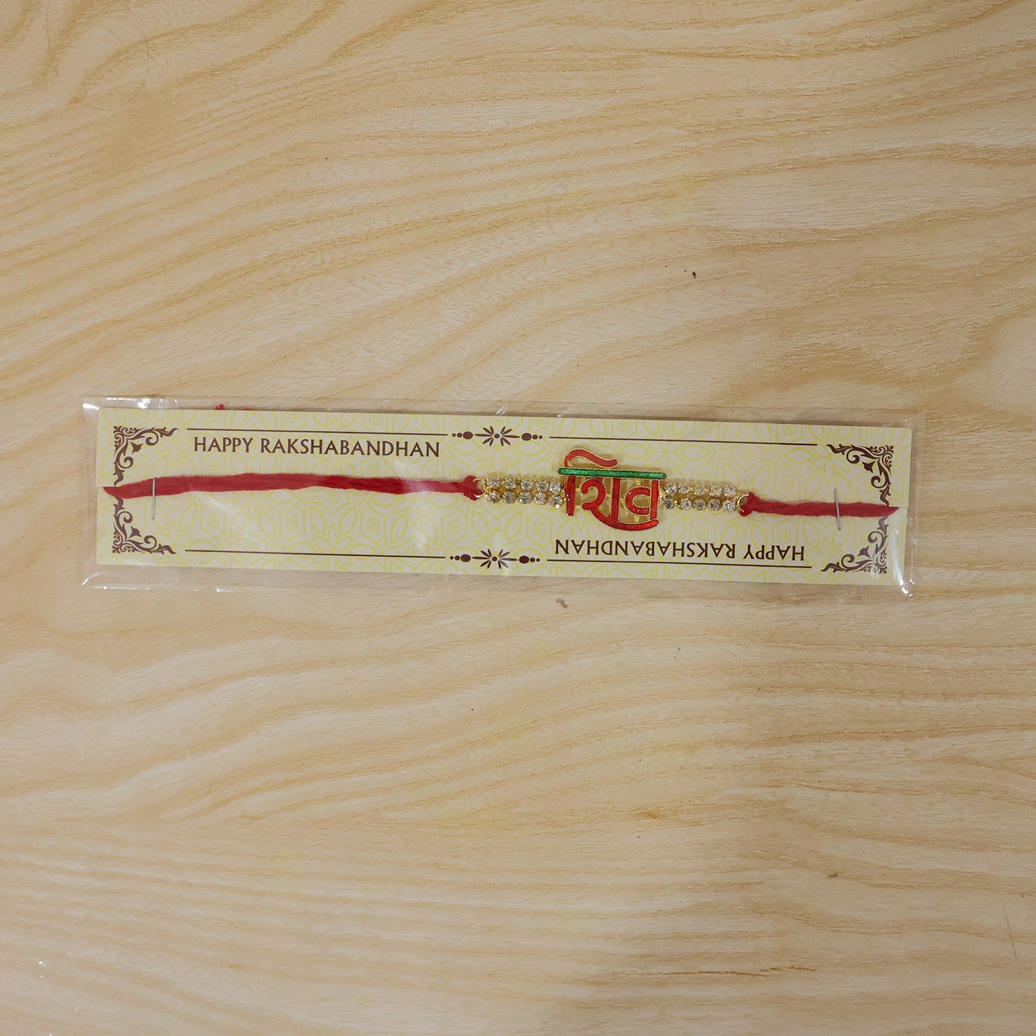 Shiv Letter Rakhi with Crystal Row and Red Mauli Thread