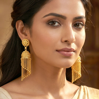 Side view of golden jhumka earrings with tassels
