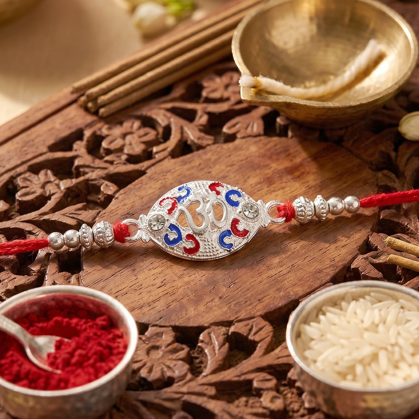 Silver Om Rakhi for Boys with Red Thread and Colorful Accents