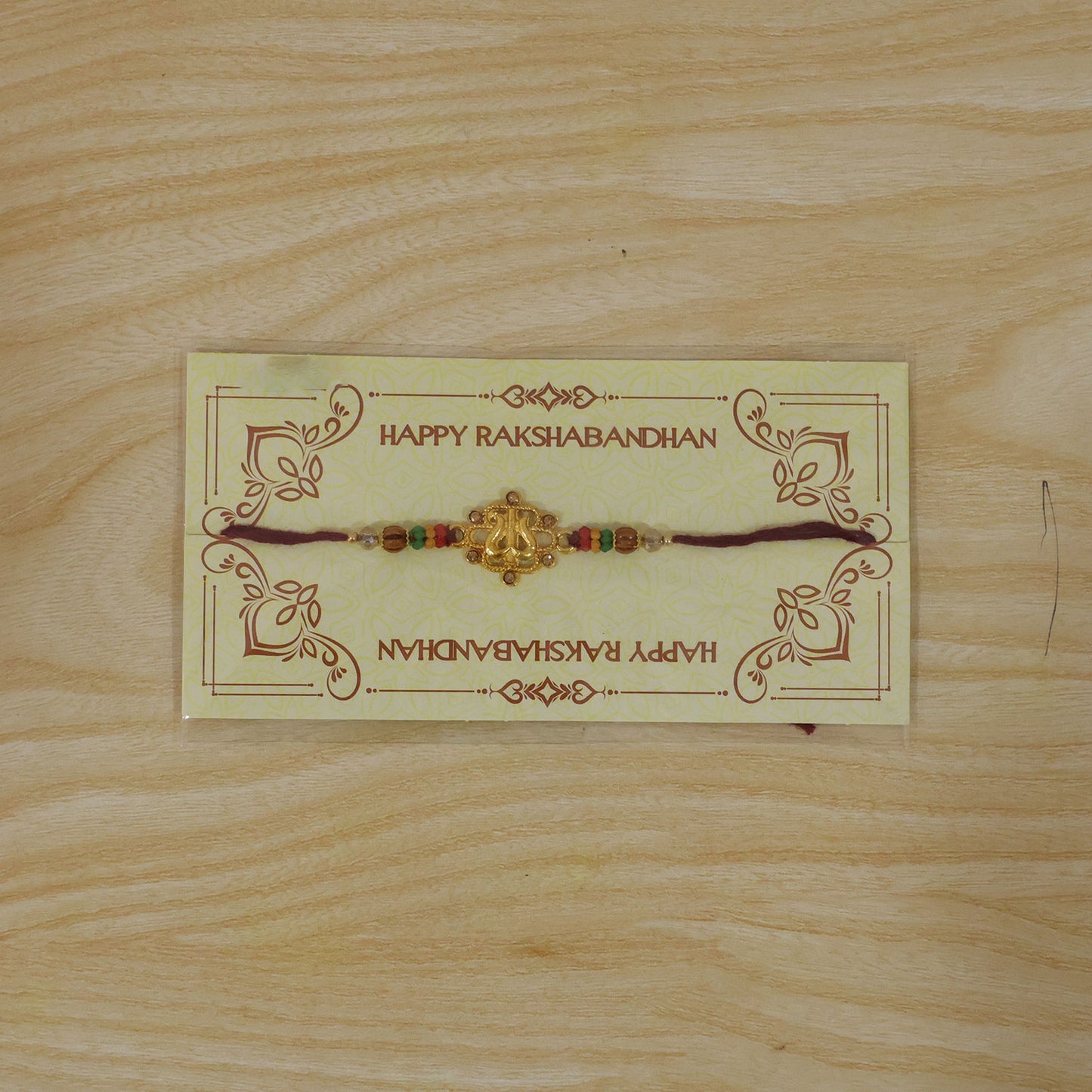 Tilak Trishul Style Devotional Rakhi with Golden Centre and Wooden Beads