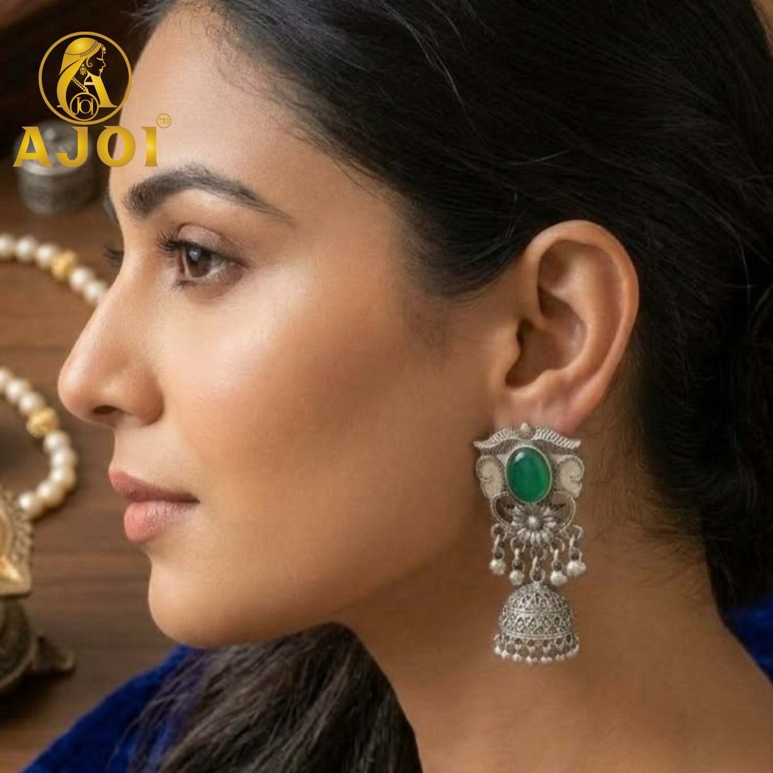 Close-up of oxidized silver jhumka earrings with vibrant stone accents