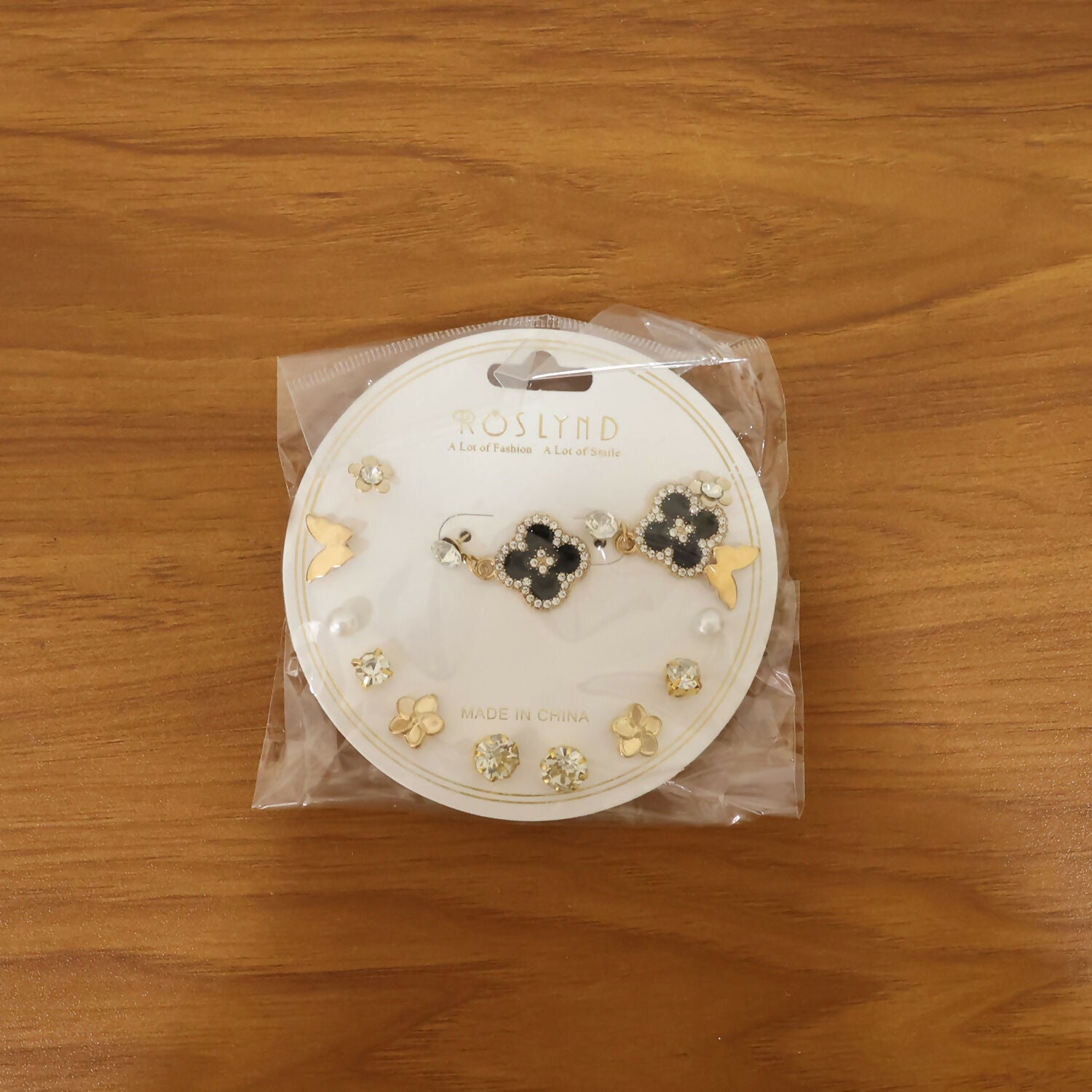Fashion earrings gift set showing floral, bow, pearl, and stud earrings in gold and black combo