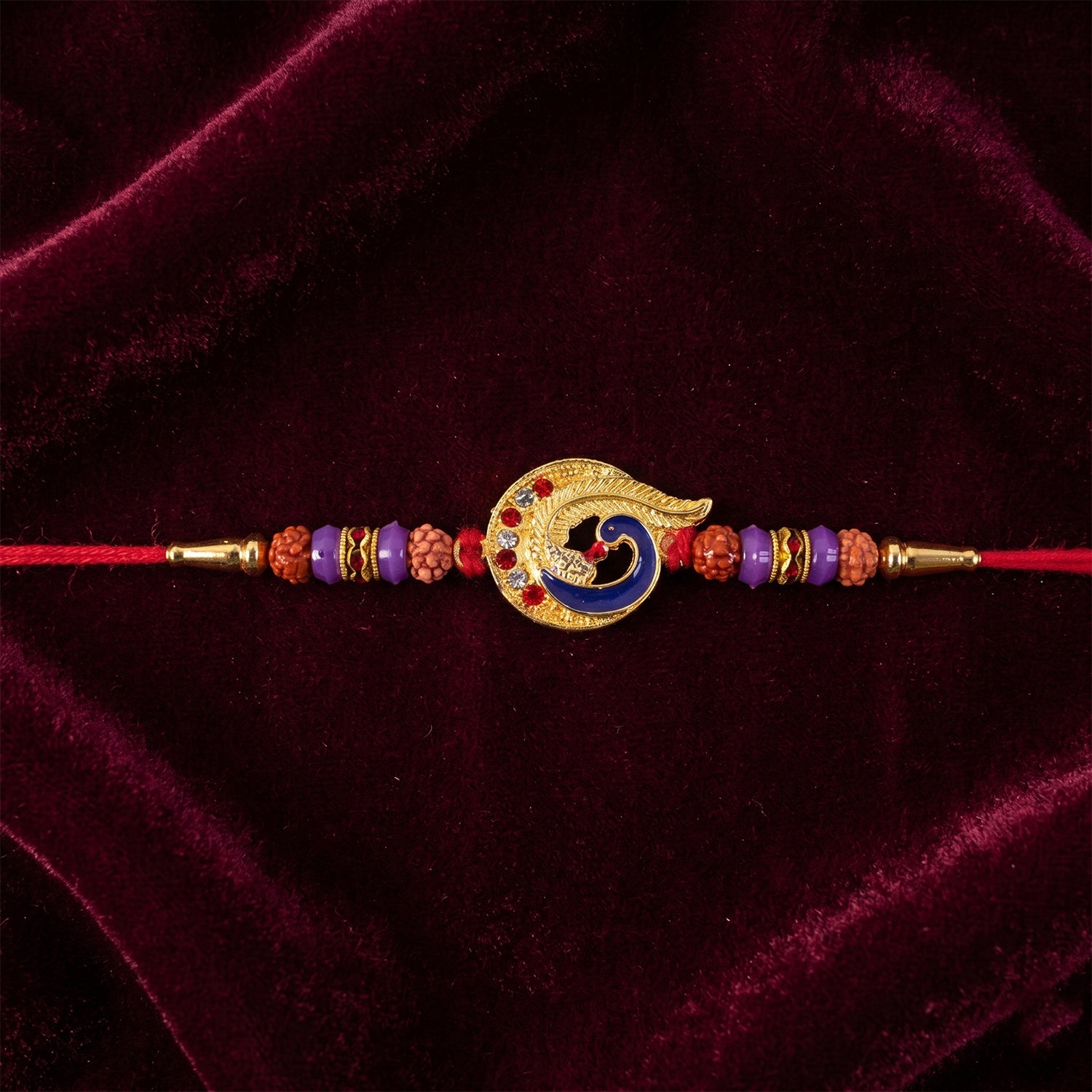Blue Peacock Rakhi with Purple Beads and Crescent Gold Frame