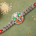 Silver-Toned Lord Ganesha Rakhi with Orange-Green Enamel, Double Crystal Chain & Red-White Thread