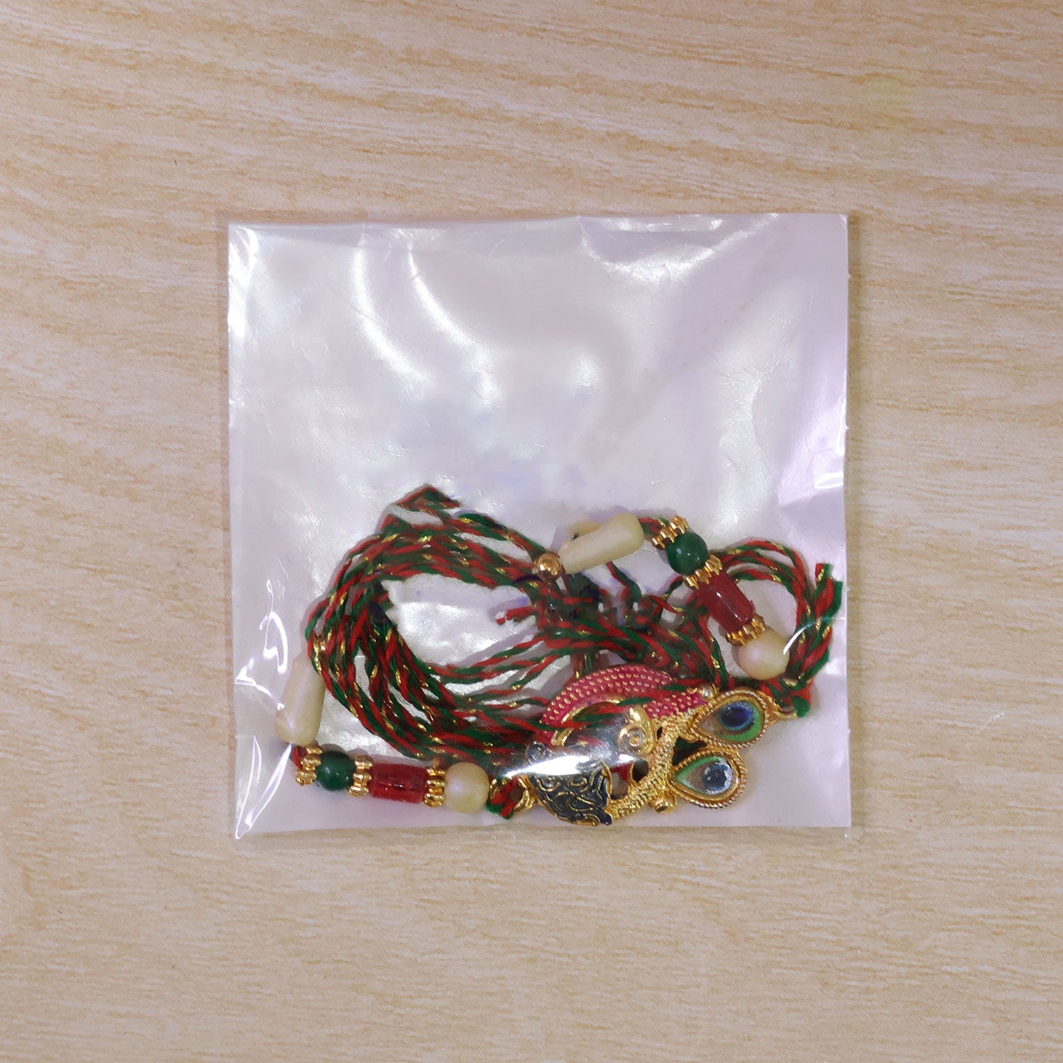 Peacock Rakhi Set with Red Thread, Gold Beads and Meenakari Accent Design