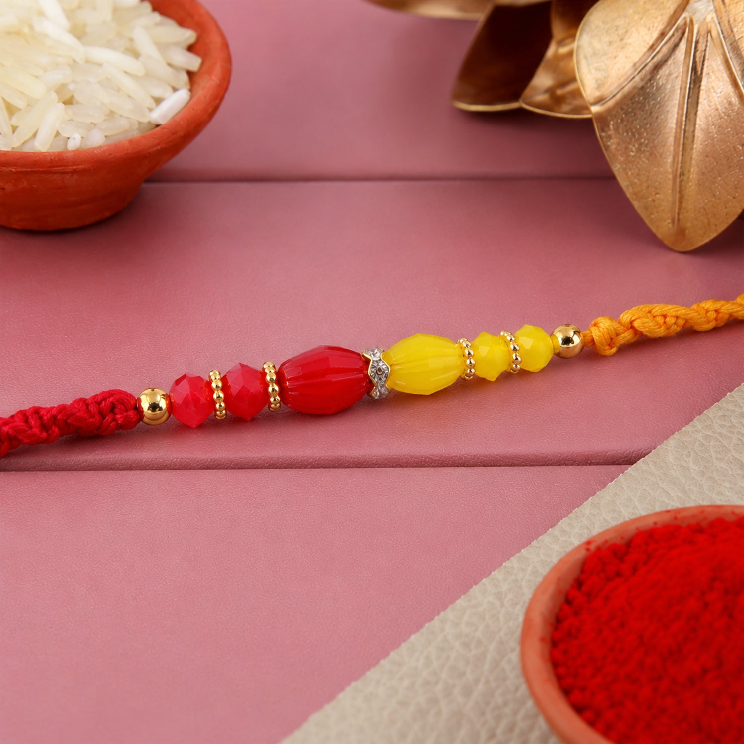 Red Thread Rakhi with Yellow and Orange Bead Pendant Accents