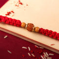 Red Braided Rakhi with a Natural Rudraksha Bead Pendant Accent