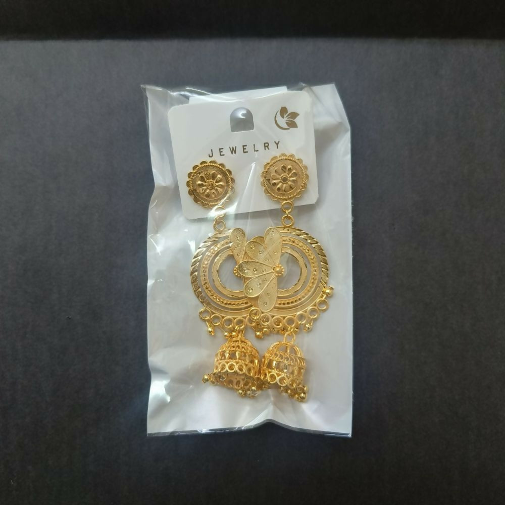 Gold jhumka earrings displayed with a traditional Indian fabric