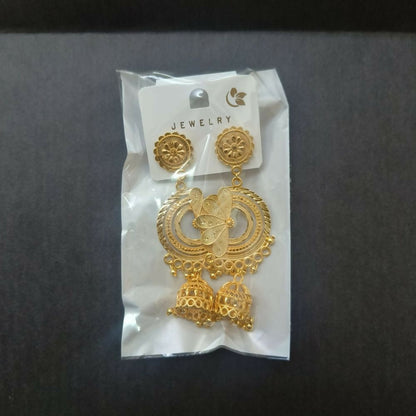 Gold jhumka earrings displayed with a traditional Indian fabric