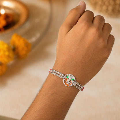 Silver-Toned Lord Ganesha Rakhi with Orange-Green Enamel, Double Crystal Chain & Red-White Thread