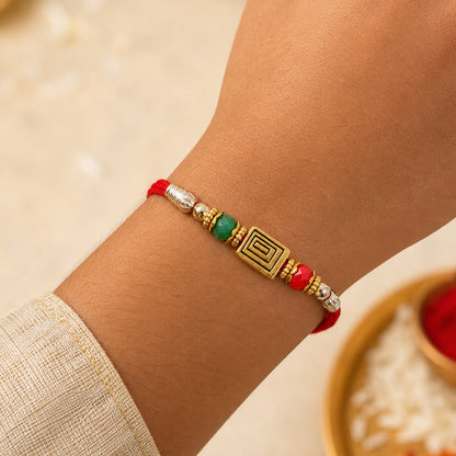 Red Thread Rakhi with Carved Golden Rectangular Charm Pendant