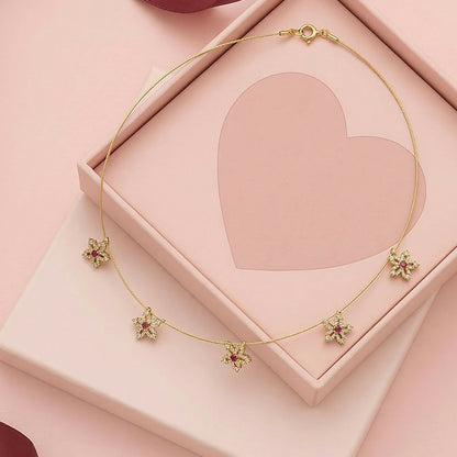 Gold chain necklace highlighting red centered floral star stones