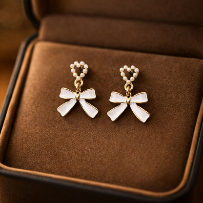 Pearl heart shaped drop earrings with gold bow accent