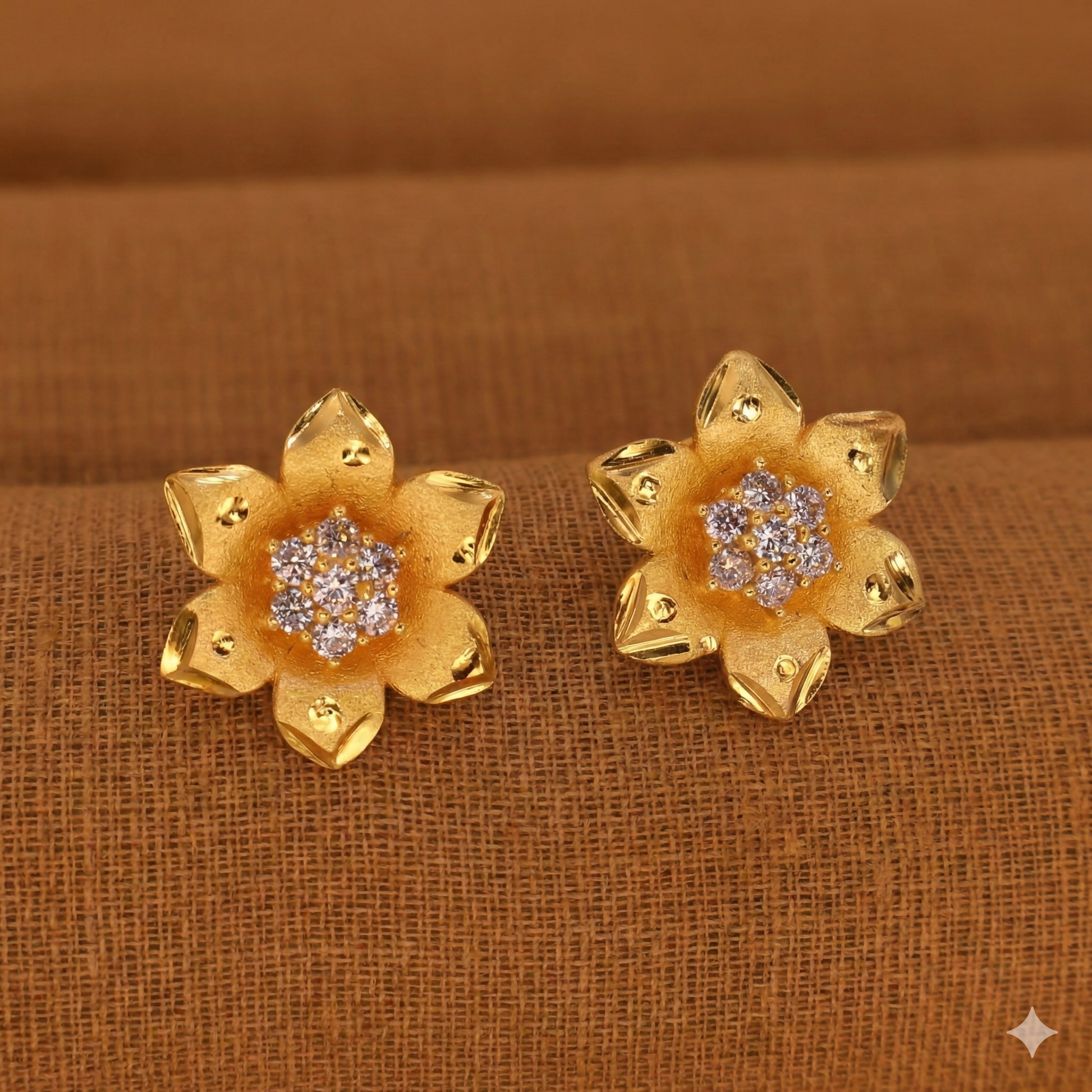 Close-up of gold plated floral stud earrings highlighting polished edges and crystal cluster
