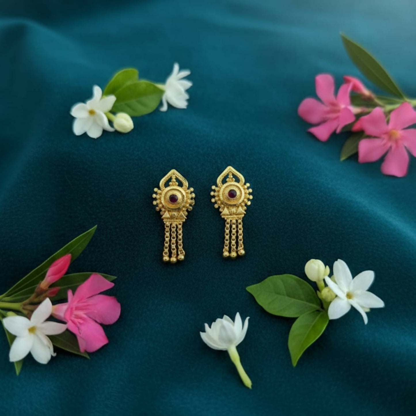 Gold plated jhumka earrings with intricate filigree design and enamel accents