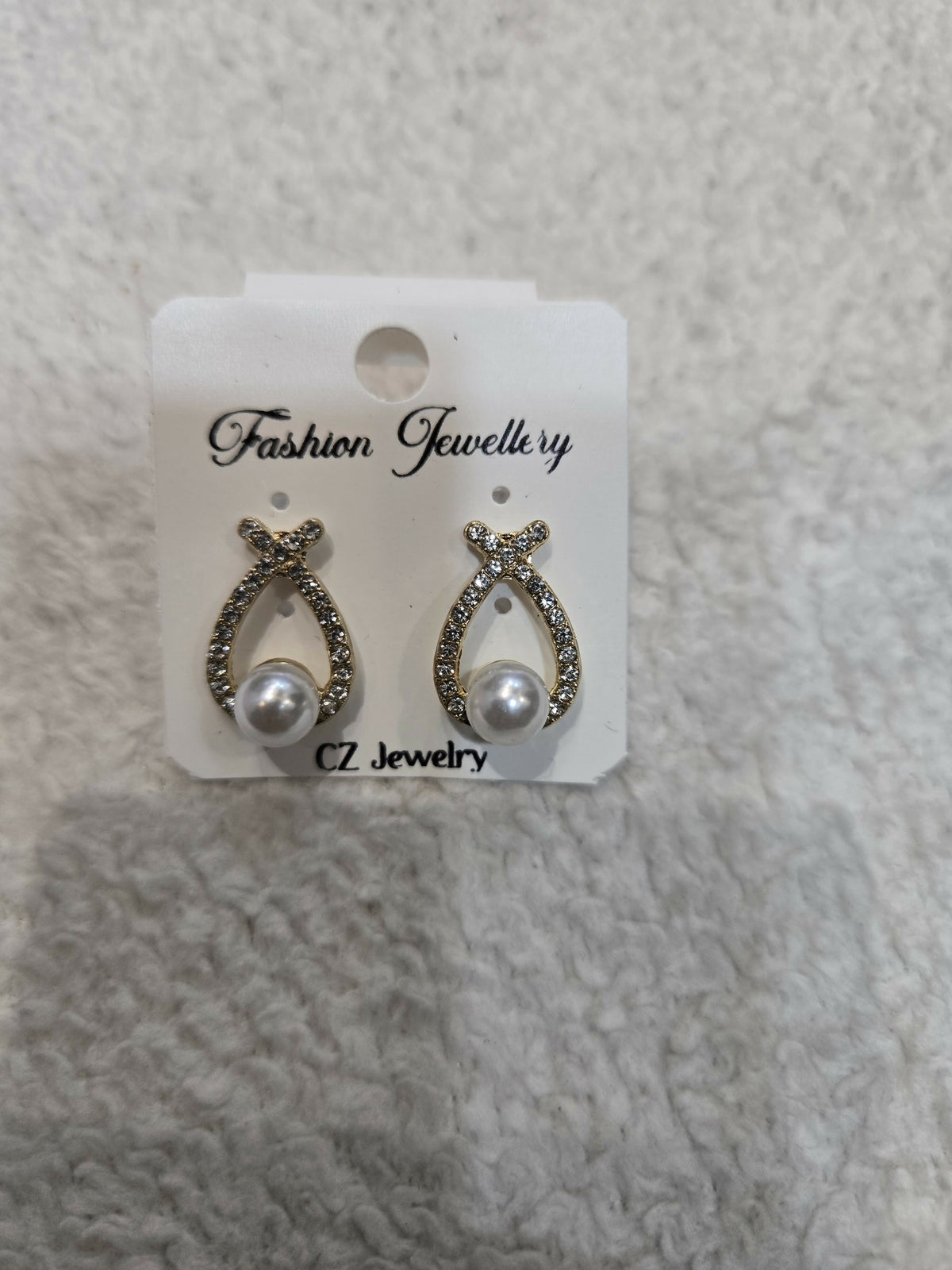 Another angle of gold-tone teardrop earrings on a white background, showcasing the design