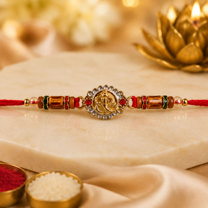 Ganesha Silver Ring Devotional Rakhi with Circular Centre and Red Green Beads