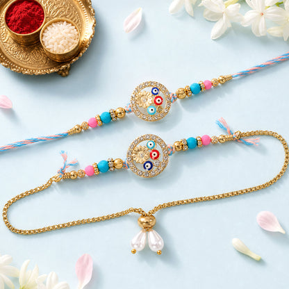 Two colorful Rakhi bracelets with evil eye beads and a gold lumba, on a light blue surface with white flowers.