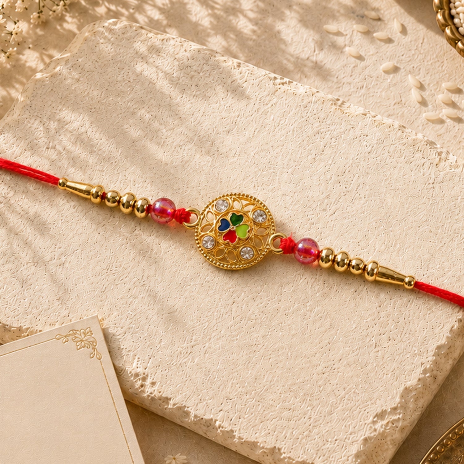 Festive Four-Petal Rakhi with Bright Enamel, Clear Stones and Translucent Beads (10pcs)