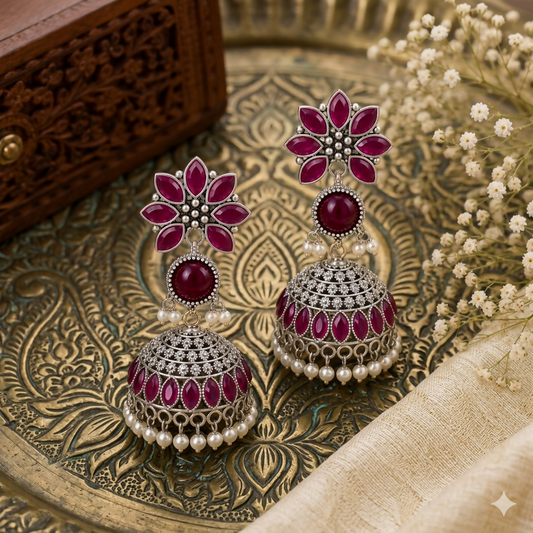Oxidized silver Jhumkha earrings with lilac stones and lavender beads on white background