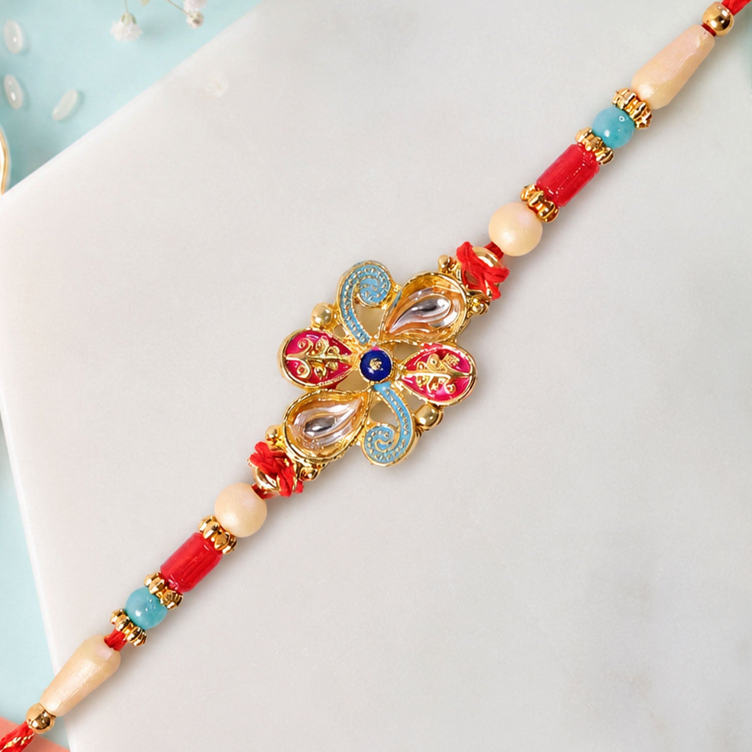 Jewel Floral Rakhi with Red Blue Beads and Bright Traditional Celebration Styling