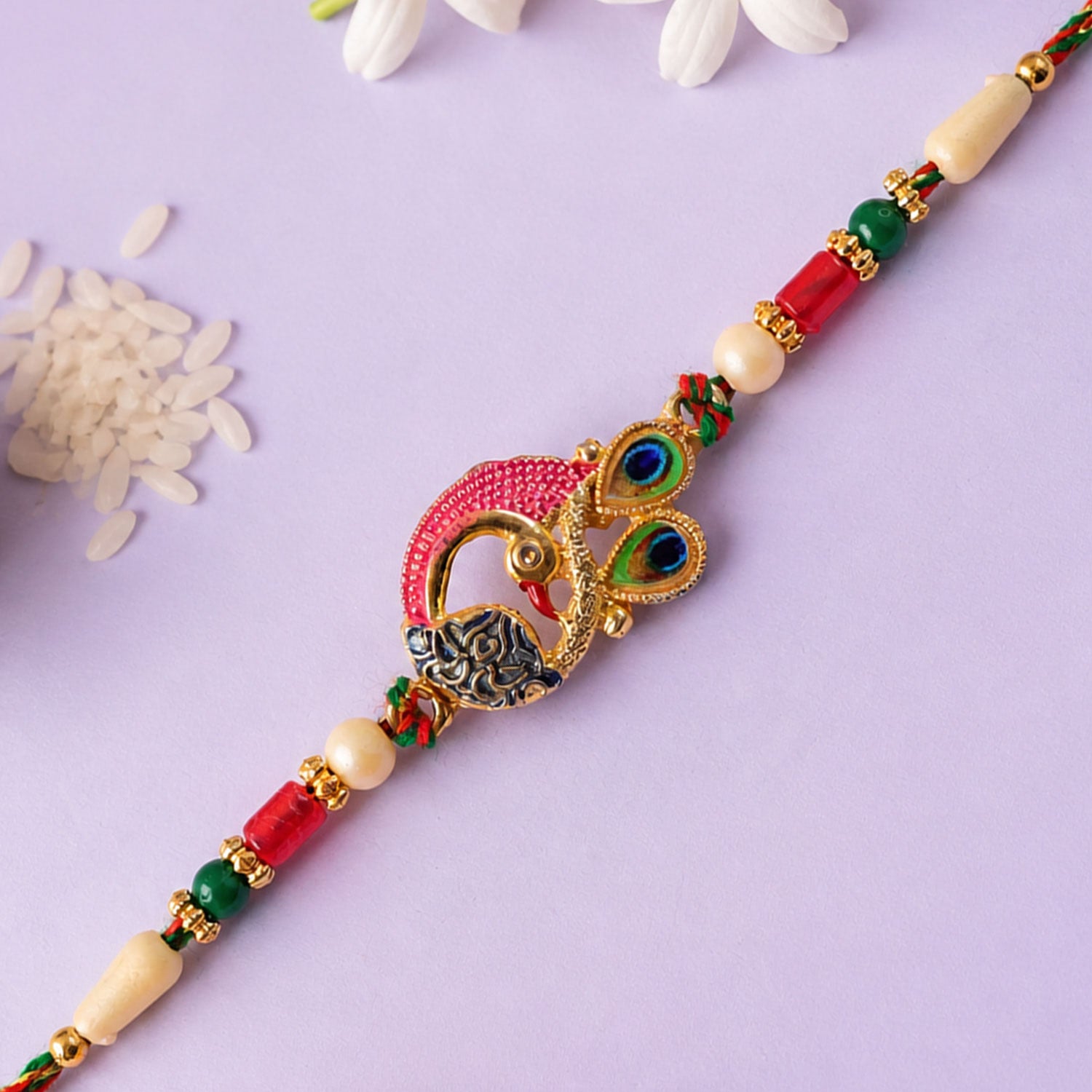 Peacock Rakhi Set with Red Thread, Gold Beads and Meenakari Accent Design