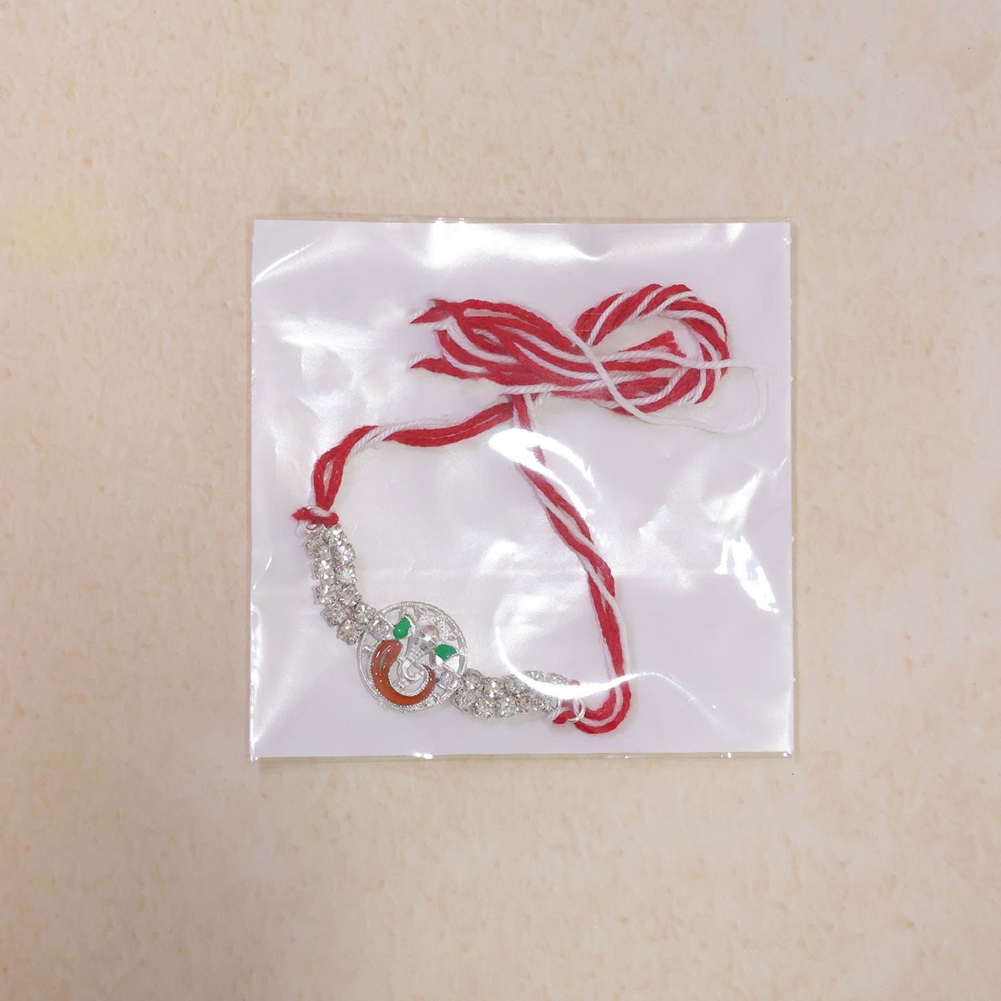 Silver-Toned Lord Ganesha Rakhi with Orange-Green Enamel, Double Crystal Chain & Red-White Thread