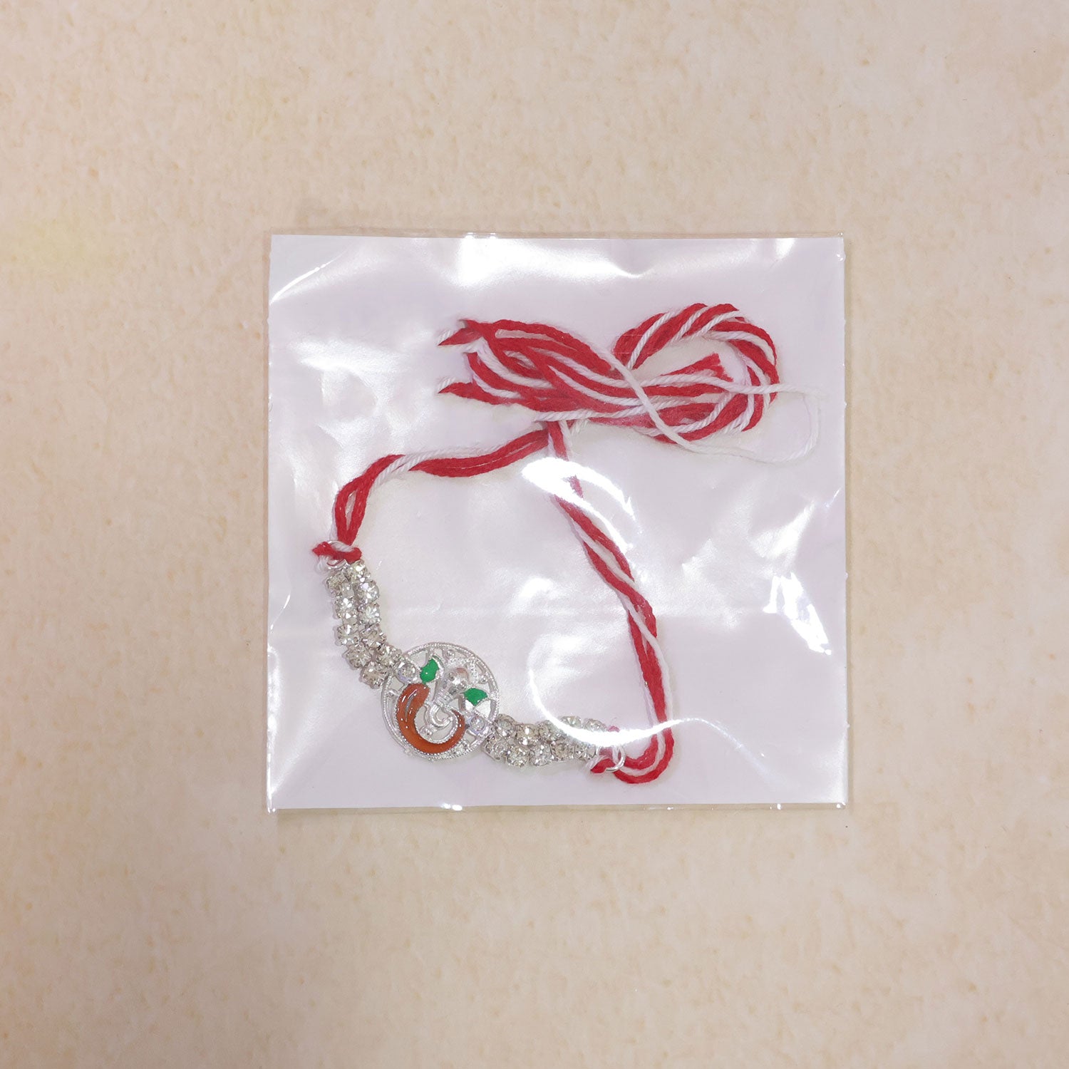 Silver-Toned Lord Ganesha Rakhi with Orange-Green Enamel, Double Crystal Chain & Red-White Thread