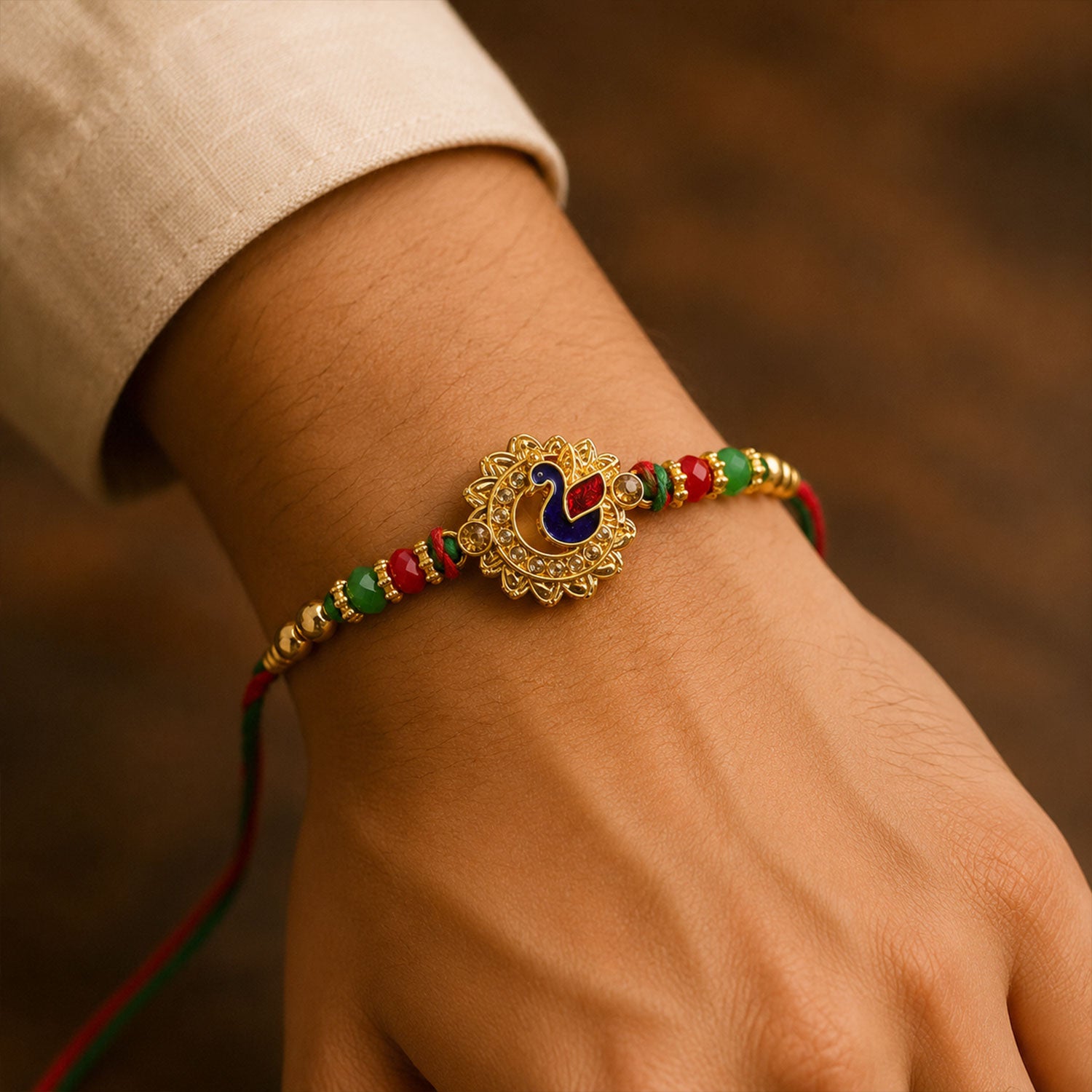Peacock Floral Golden Rakhi with Blue Green Enamel, Red Beads and Decorative Centre