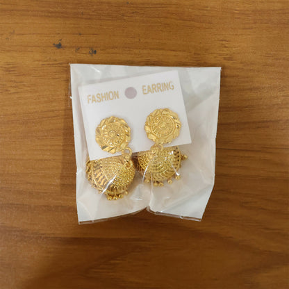 Pair of gold jhumka earrings hanging elegantly