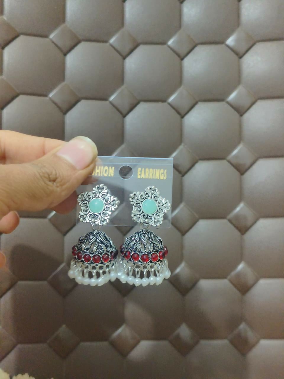 Model wearing oxidized silver jhumka earrings with mint green and ruby red stones