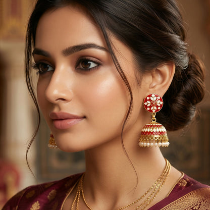 Close-up of red floral jhumka earrings showcasing gold-tone details
