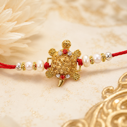 Gold Turtle Motif Rakhi with Pearl Sides and Classic Red Thread