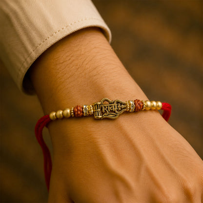 Shiv Trishul Damru Devotional Rakhi with Engraved Shiv Word, Golden Plate and Red Stones