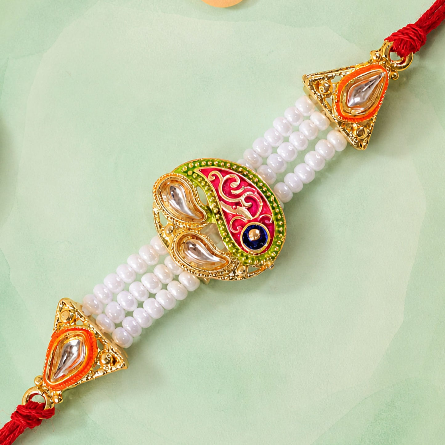 Pearl Paisley Rakhi with Red Thread and Golden Festive Brother Gift Presentation