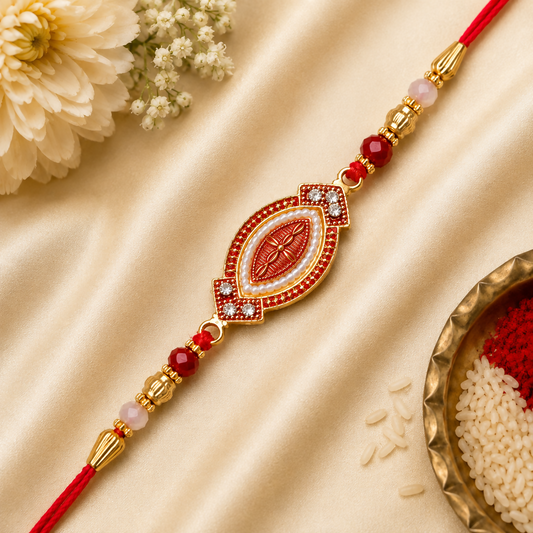 A red and gold bracelet with an oval centerpiece, adorned with white beads and red stones, lies on a golden silk cloth with