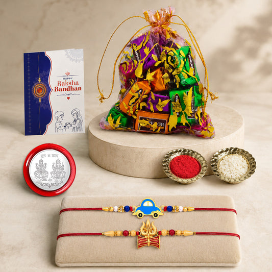 A Raksha Bandhan gift set including two rakhis, a bag of chocolates, a greeting card, and small bowls of kumkum and rice.