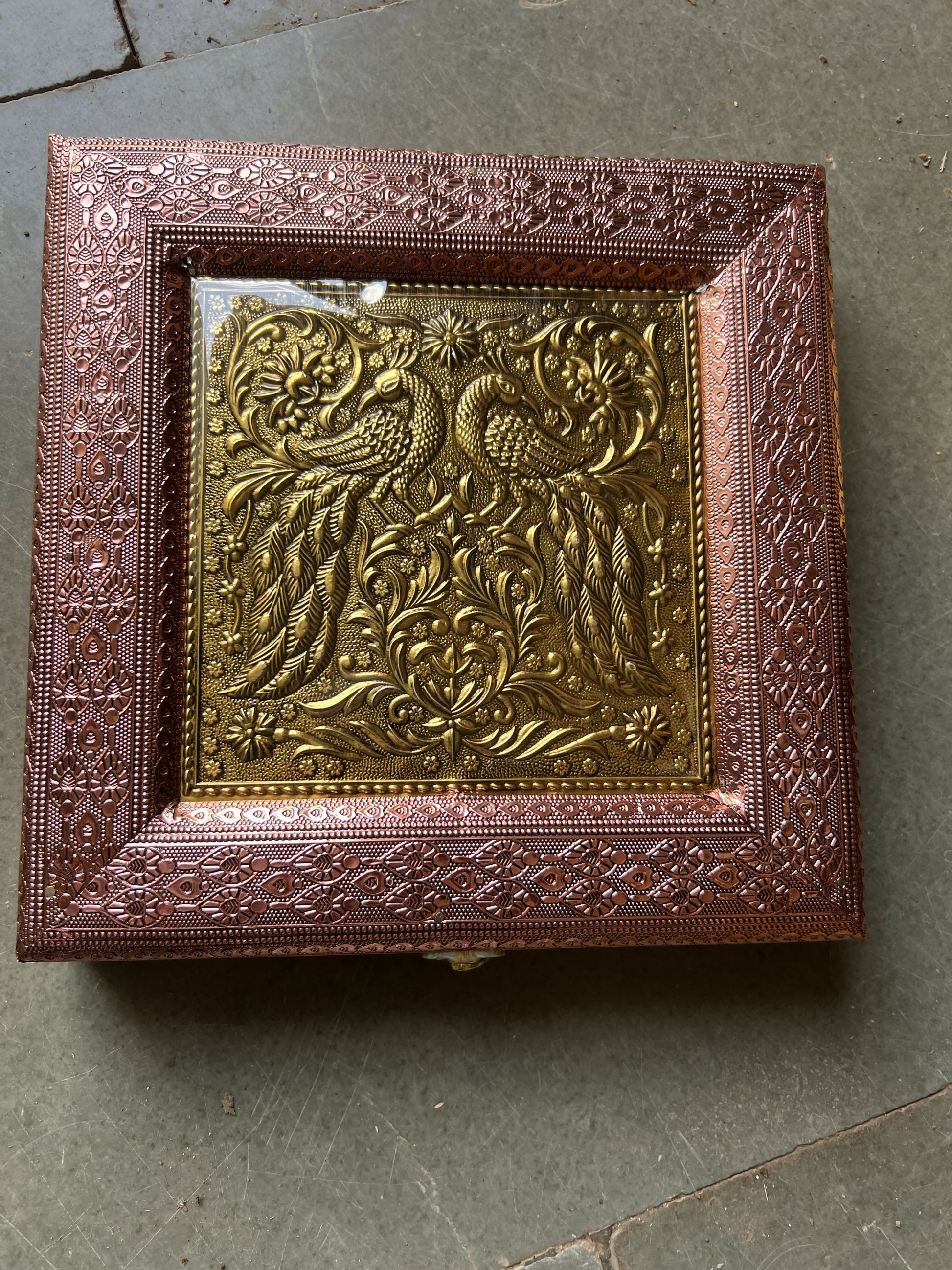 Top view showing clear protective layer on peacock embossed box