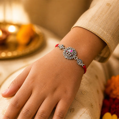 Premium Rakhi showcasing Silver Om Leaf Charm, gold trims and chain look for Gift