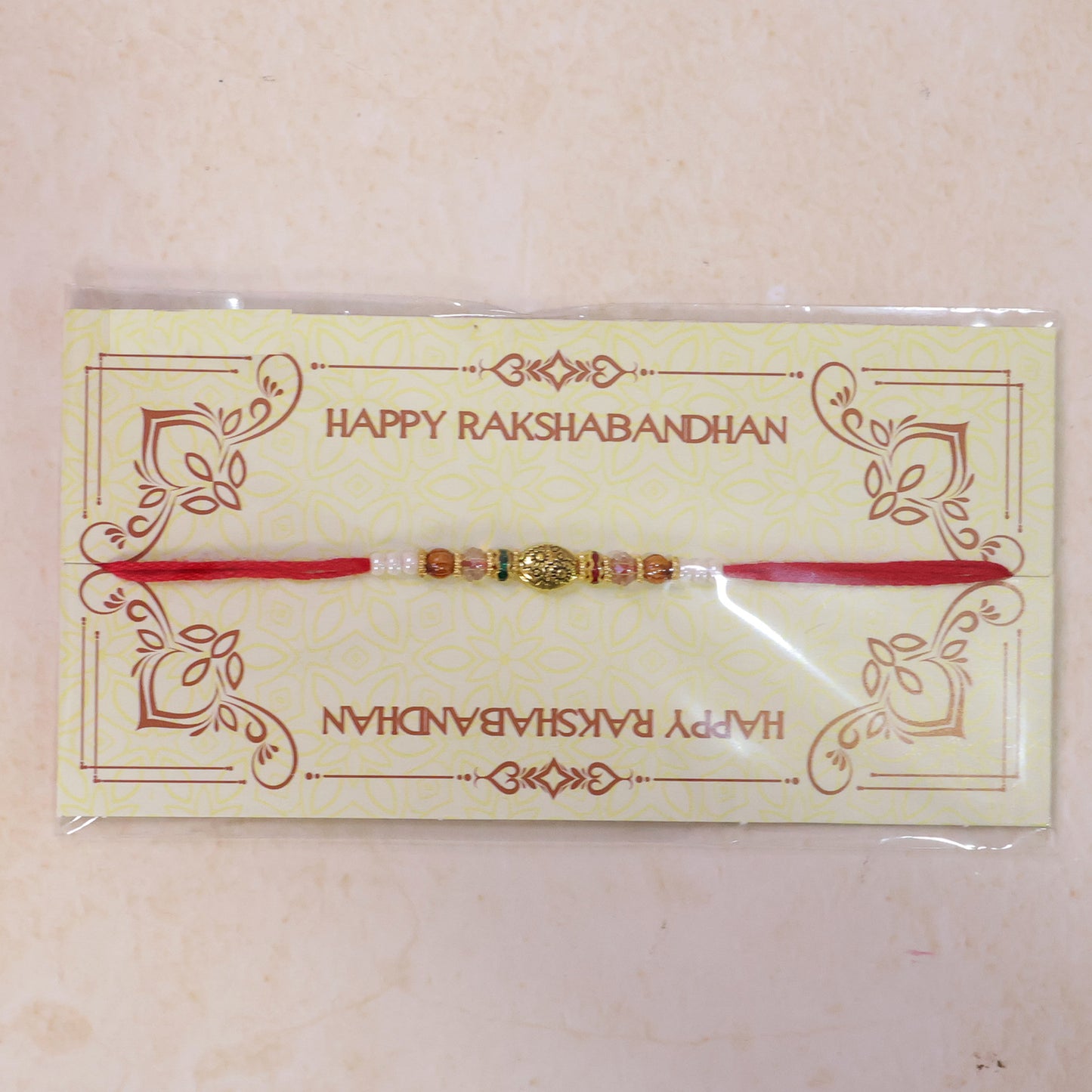 Red Thread Rakhi with Floral Gold Oval Charm and Multicolour Beads